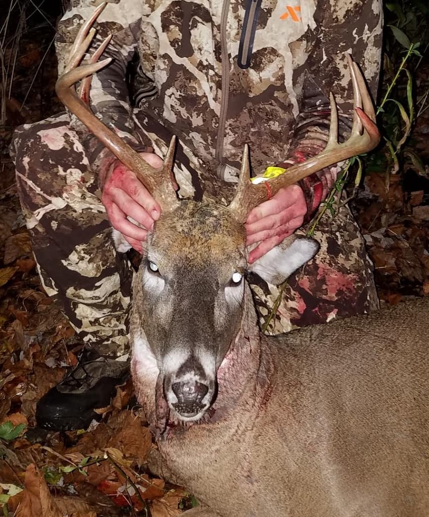 hunting wearing first lite cipher posing with a 10 point buck