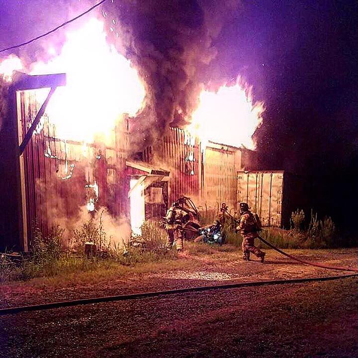 firefighters fighting fire at large barn